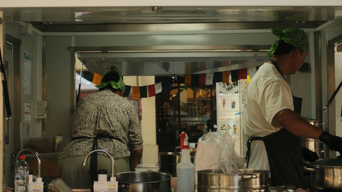Two cooks working inside a food truck kitchen